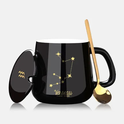 Black mug with star constellation design, spoon, and lid on a white background
