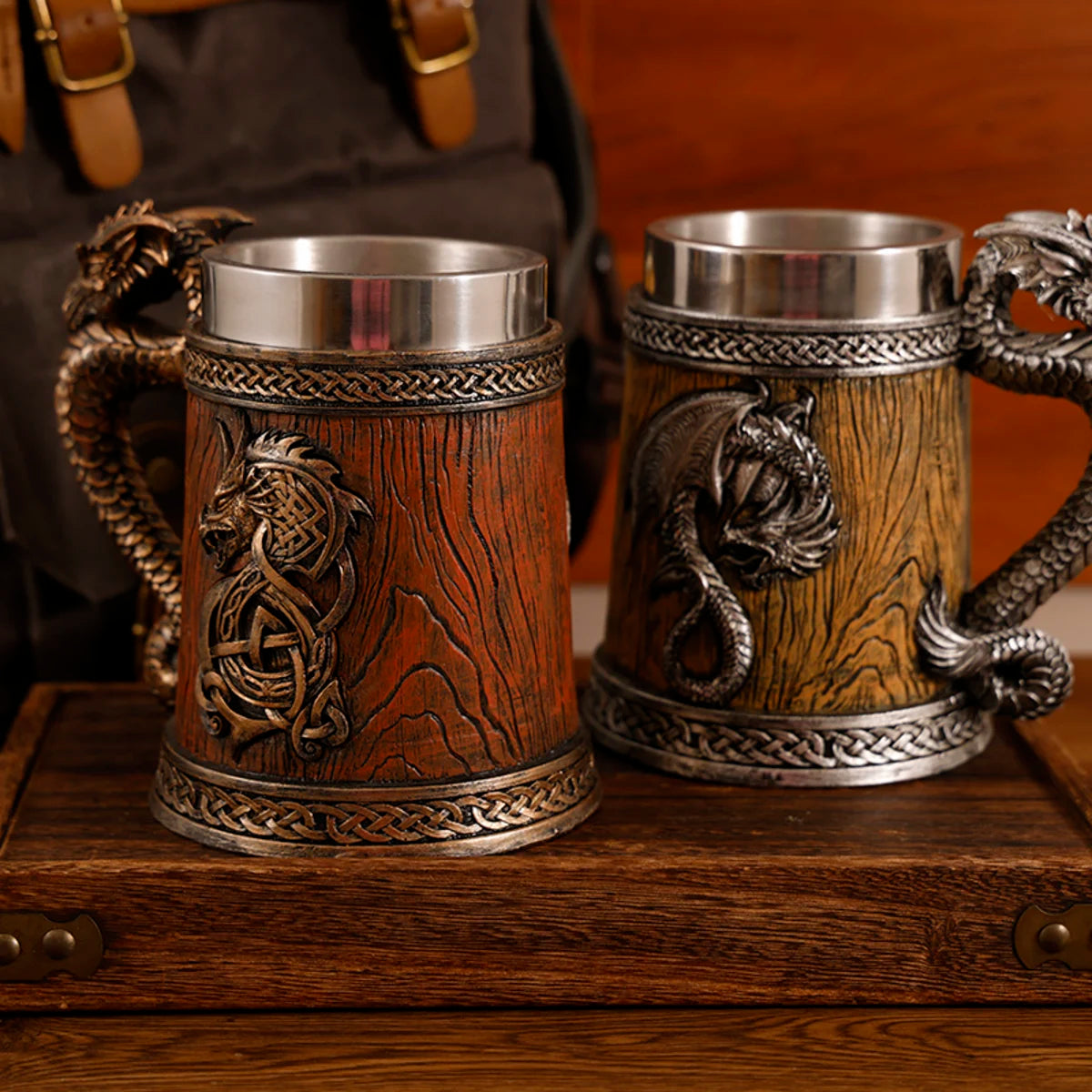 Two ornate wooden mugs with metal accents on a wooden surface.